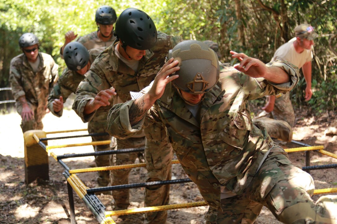 U.S. Special Forces team members maneuver through a high-step event during the Fuerzas Comando 2015 obstacle course event in Poptun, Guatemala, July 19, 2015.