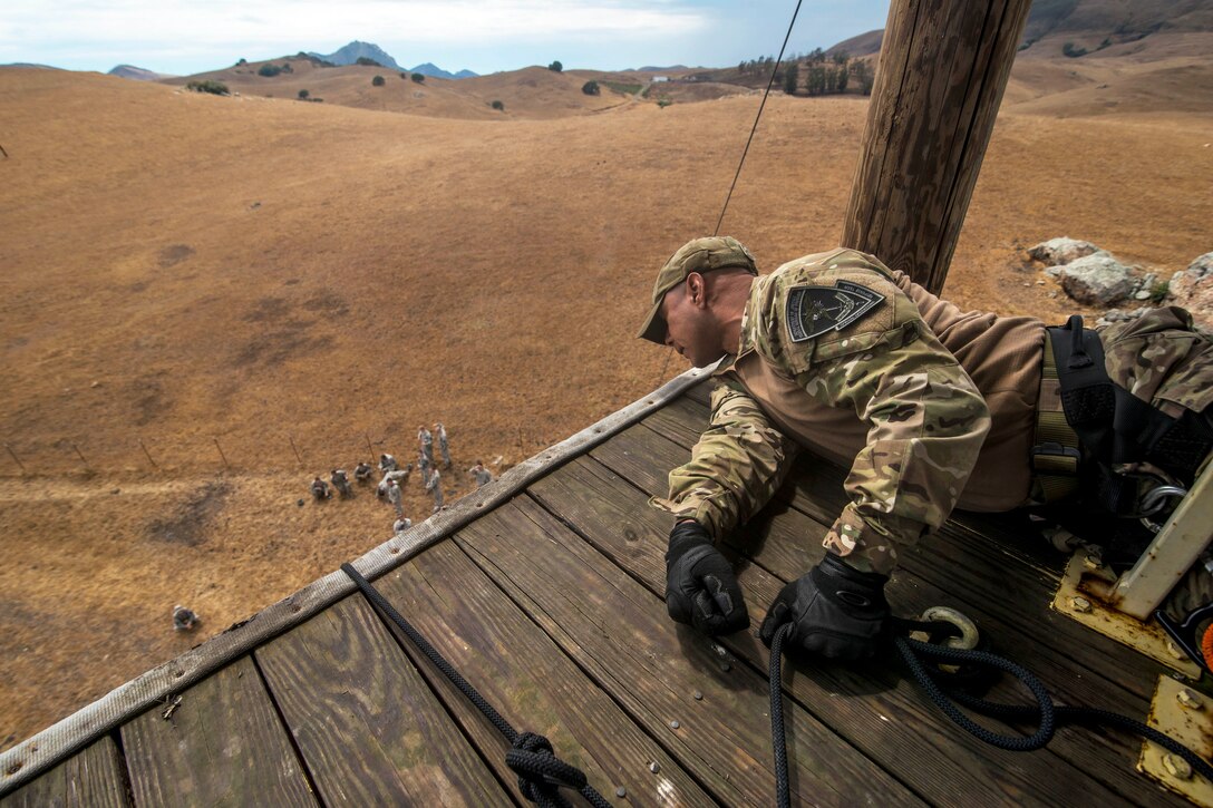 A rappel master instructs a soldier descending a 100-foot tower during a sapper leader course on Camp San Luis Obispo in San Luis Obispo County, Calif., July 19, 2015. The rappel master is assigned to the U.S. Department of Justice, Special Operations Response Team.