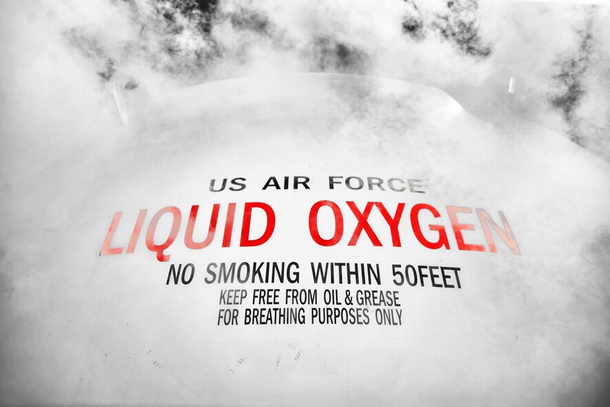 A 6,000-gallon liquid oxygen tank is surrounded by evaporated oxygen July 29, 2015, at Yokota Air Base, Japan. Liquid oxygen has a boiling point of -297 degrees Fahrenheit and is used as breathing oxygen for pilots flying over 10,000 feet. The graphic was created using Adobe Photoshop to turn the image into black and white and reintroduce its original red lettering. (U.S. Air Force graphic by Airman 1st Class Delano Scott/Released) 