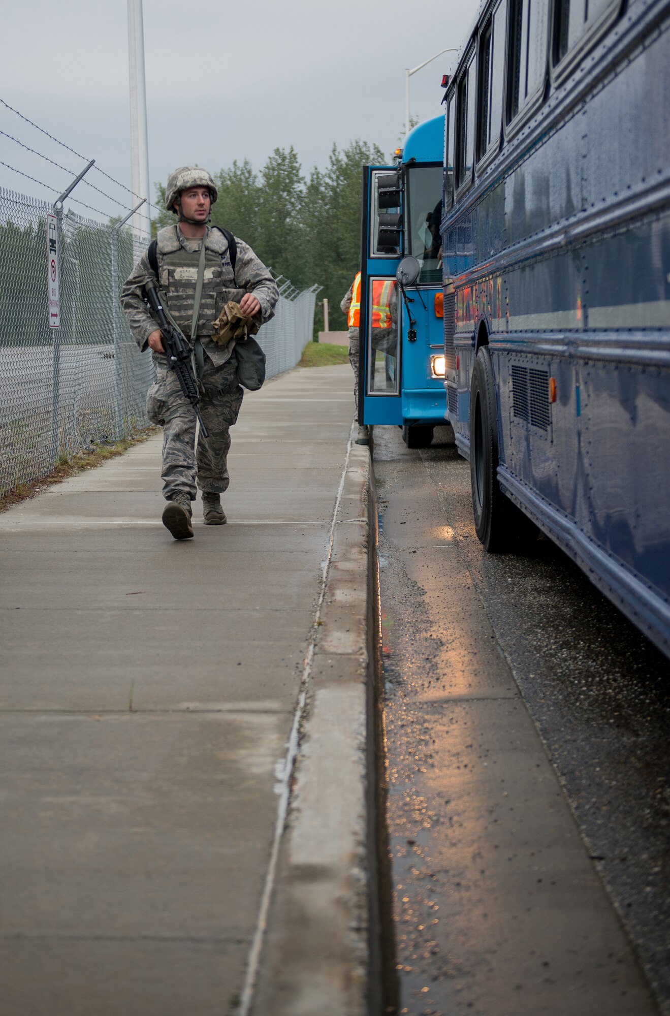 U.S. Air Force 1st Lt. Brett Brunner, the operational readiness exercise (ORE) chalk one troop commander from the 354th Civil Engineer Squadron, walks alongside buses full of Airmen preparing for a simulated deployment at the Stevens Joint Mobility Complex, July 28, 2015, at Eielson Air Force Base, Alaska. OREs test the base’s response to situations such as short-notice deployments or disasters. (U.S. Air Force photo by Staff Sgt. Shawn Nickel/Released)