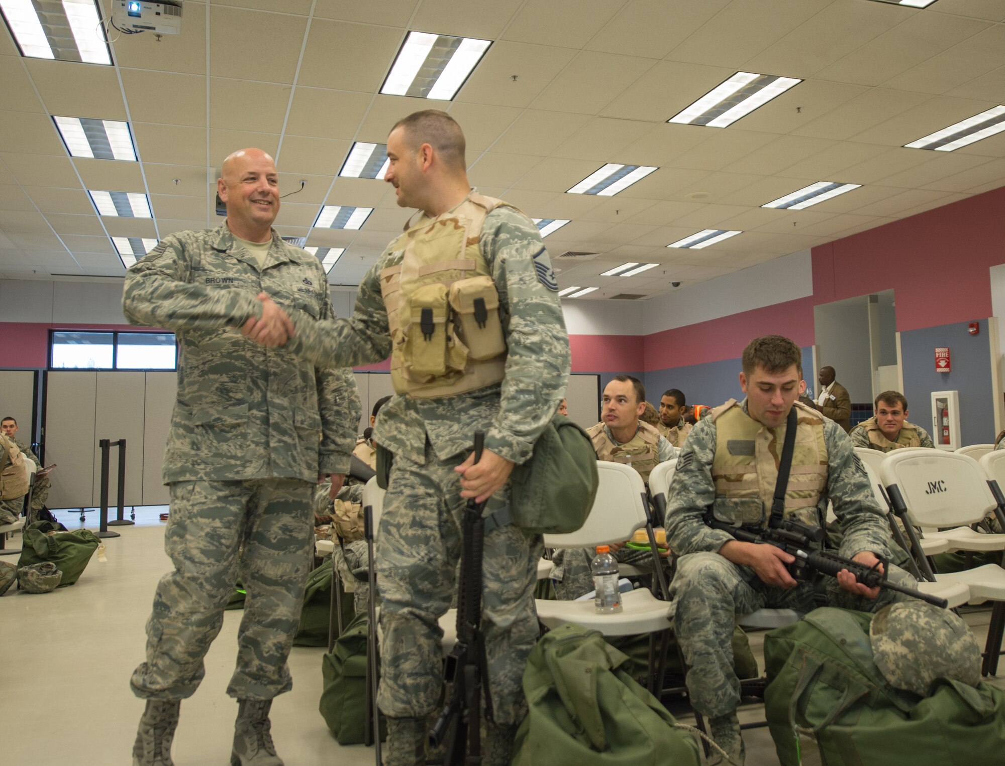 U.S. Air Force Chief Master Sgt. Michael Brown, the 354th Fighter Wing command chief, greets Airmen simulating deployment during an operational readiness exercise (ORE) July 28, 2015, at Eielson Air Force Base, Alaska. Brown and other wing leaders showed their support for the Airmen participating in the ORE. (U.S. Air Force photo by Staff Sgt. Shawn Nickel/Released)