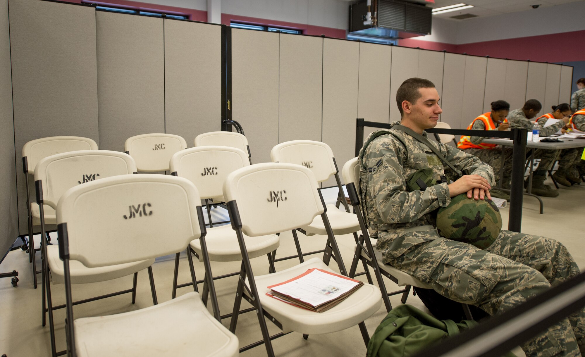 U.S. Air Force Airman 1st Class Brett Jones, a 354th Civil Engineer Squadron chemical, biological, radiological, nuclear defense technician, waits in the discrepancy holding area during an operational readiness exercise July 28, 2015, at Eielson Air Force Base, Alaska. Anyone requiring changes to paperwork or in need of further training are moved to the holding area until they can continue through the pre-deployment briefing line. (U.S. Air Force photo by Staff Sgt. Shawn Nickel/Released)