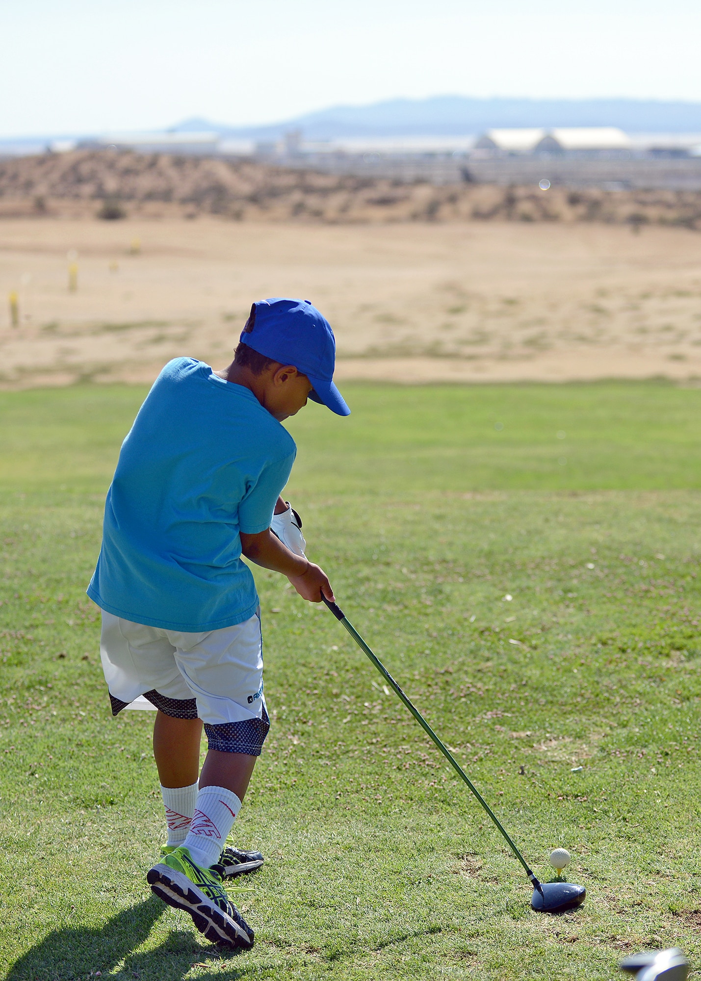Eight-year-old Riley, practices with his driver on the golf range during the three-day junior golf camp, held July 22 to 24, at the Muroc Lake Golf Course. (U.S. Air Force photo by Jet Fabara)