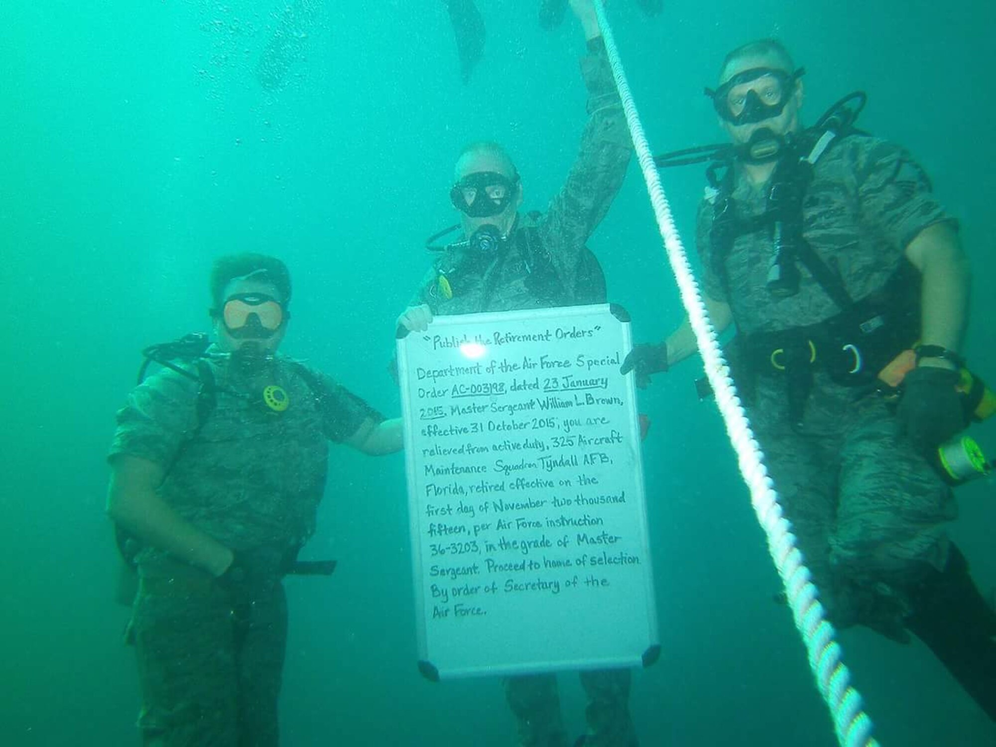 Master Sgt. William Brown, 95th Fighter Squadron tactical aircraft maintenance section flight chief (middle), retired July 25 under water. Brown held his retirement ceremony approximately 70 feet under the ocean. (U.S. Air Force courtesy photo/Released)