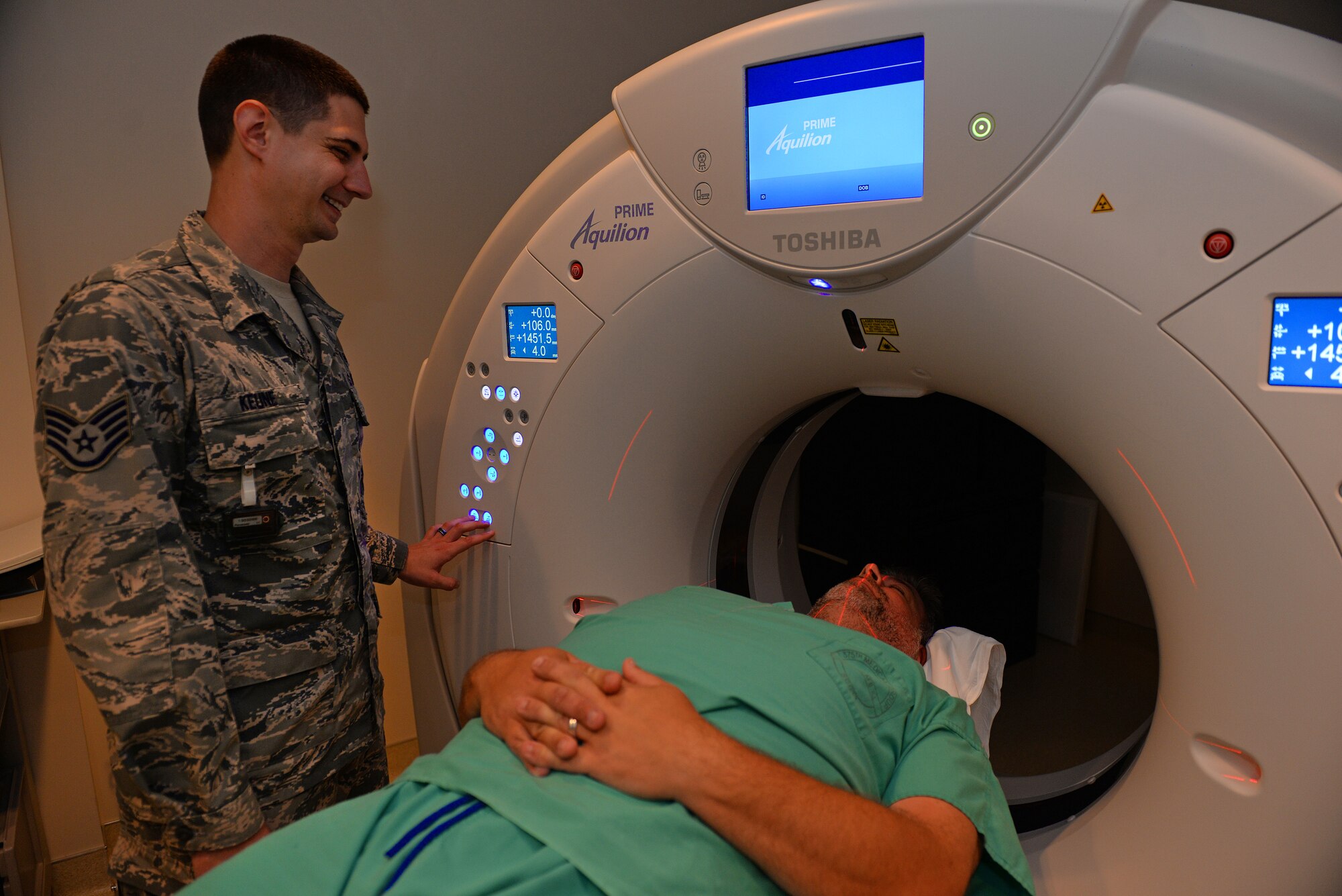 Staff Sgt. Justin Keune, 375th Medical Support Squadron Picture Archive Communication System Administrator, and Jerald Aylsworth, CAT Scan Quality Control Supervisor, show one position a patient can be scanned around the head, Scott Air Force Base, July 20, 2015. Keune processes an average of 45 patient records a day. (U.S. Air Force photo by Airman 1st Class Erica Holbert-Siebert)