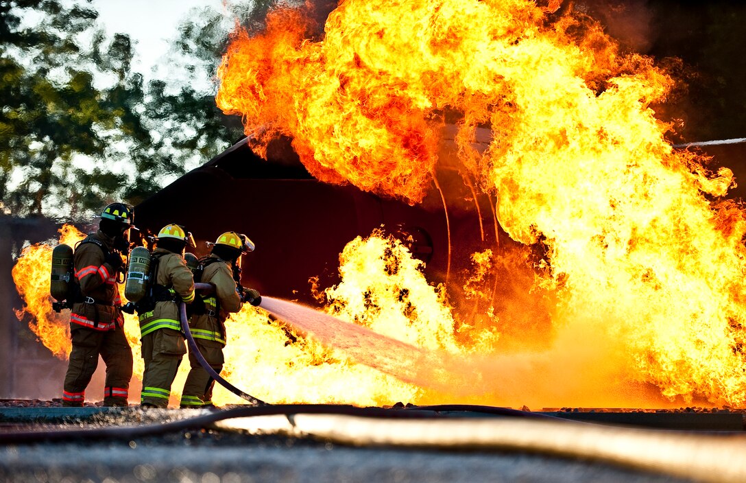 Members of the 122nd Fighter Wing Fire Department, from the 122nd Fighter Wing in Fort Wayne, Ind., battle a simulated aircraft fire, July 22, 2015, at the Combat Readiness Training Center in Alpena, Mich. (Air National Guard photo by Staff Sgt. William Hopper)