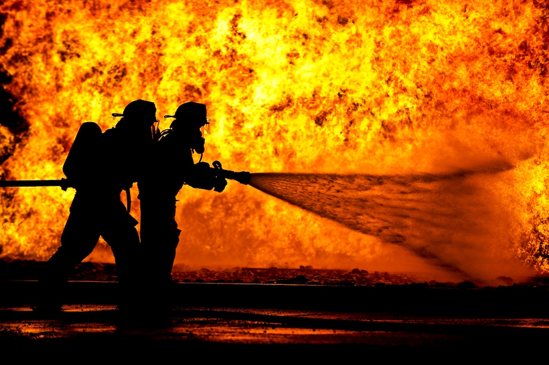 Members of the 122nd Fighter Wing Fire Department, from the 122nd Fighter Wing in Fort Wayne, Ind., battle a simulated aircraft fire, July 22, 2015, at the Combat Readiness Training Center in Alpena, Mich. (Air National Guard photo by Staff Sgt. William Hopper)