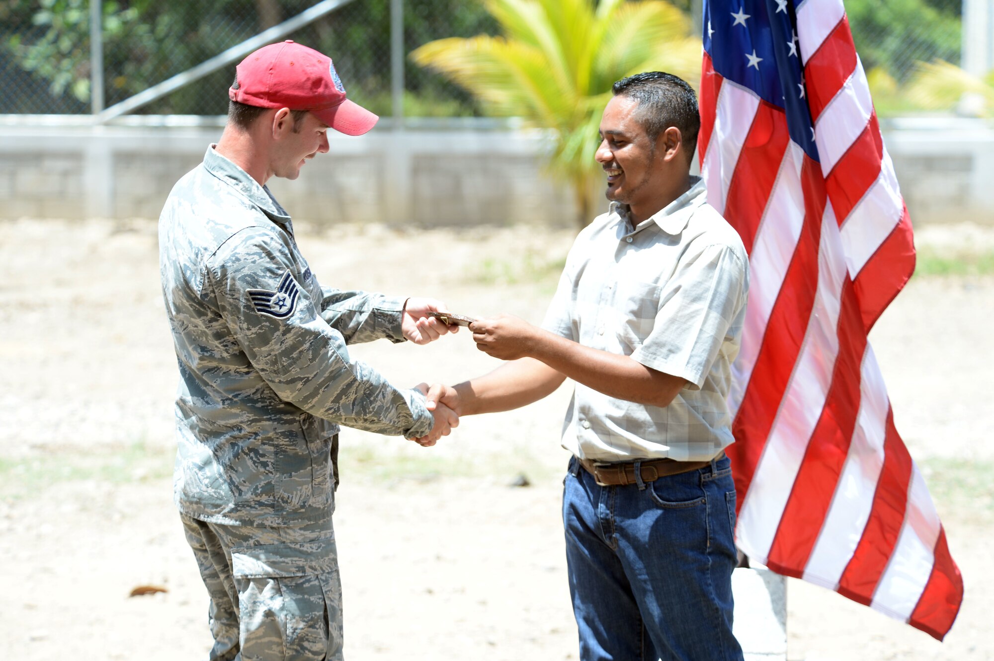 Gabriela Mistral School Principal Abraham Ruiz hands a gift to U.S. Air Force Staff Sgt. Nathan Rosier, 823rd Expeditionary RED HORSE Squadron structural craftsman and Tampa, Fla., native, as a token of his appreciation for the work that he and other members of the New Horizons Honduras 2015 training exercise performed in the construction of a new two-classroom schoolhouse during a ribbon-cutting ceremony at Ocotes Alto, Honduras, July 28, 2015. Ruiz gave a gift to every member of the New Horizons team that worked in the construction of the building. New Horizons was launched in the 1980s and is an annual joint humanitarian assistance exercise that U.S. Southern Command conducts with a partner nation in Central America, South America or the Caribbean. The exercise improves joint training readiness of U.S. and partner nation civil engineers, medical professionals and support personnel through humanitarian assistance activities. (U.S. Air Force photo by Capt. David J. Murphy/Released)