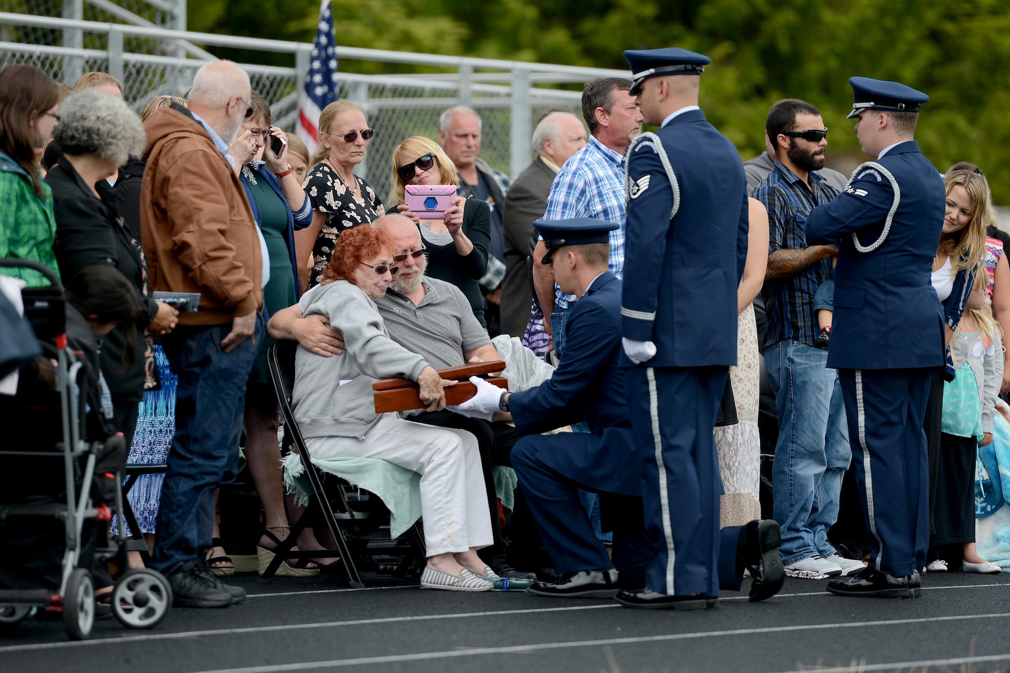 Capt. Brian Meredith, 627th Force Support Squadron flight commander, presents Mary Jarvis, Tech. Sgt. Hugh Sherburn’s sister, with a flag July 25, 2015, during an active duty honors ceremony at Waldport High School, Ore. During an active duty honors ceremony, the next of kin is given the funeral flag. (U.S. Air Force photo/Airman 1st Class Keoni Chavarria)
