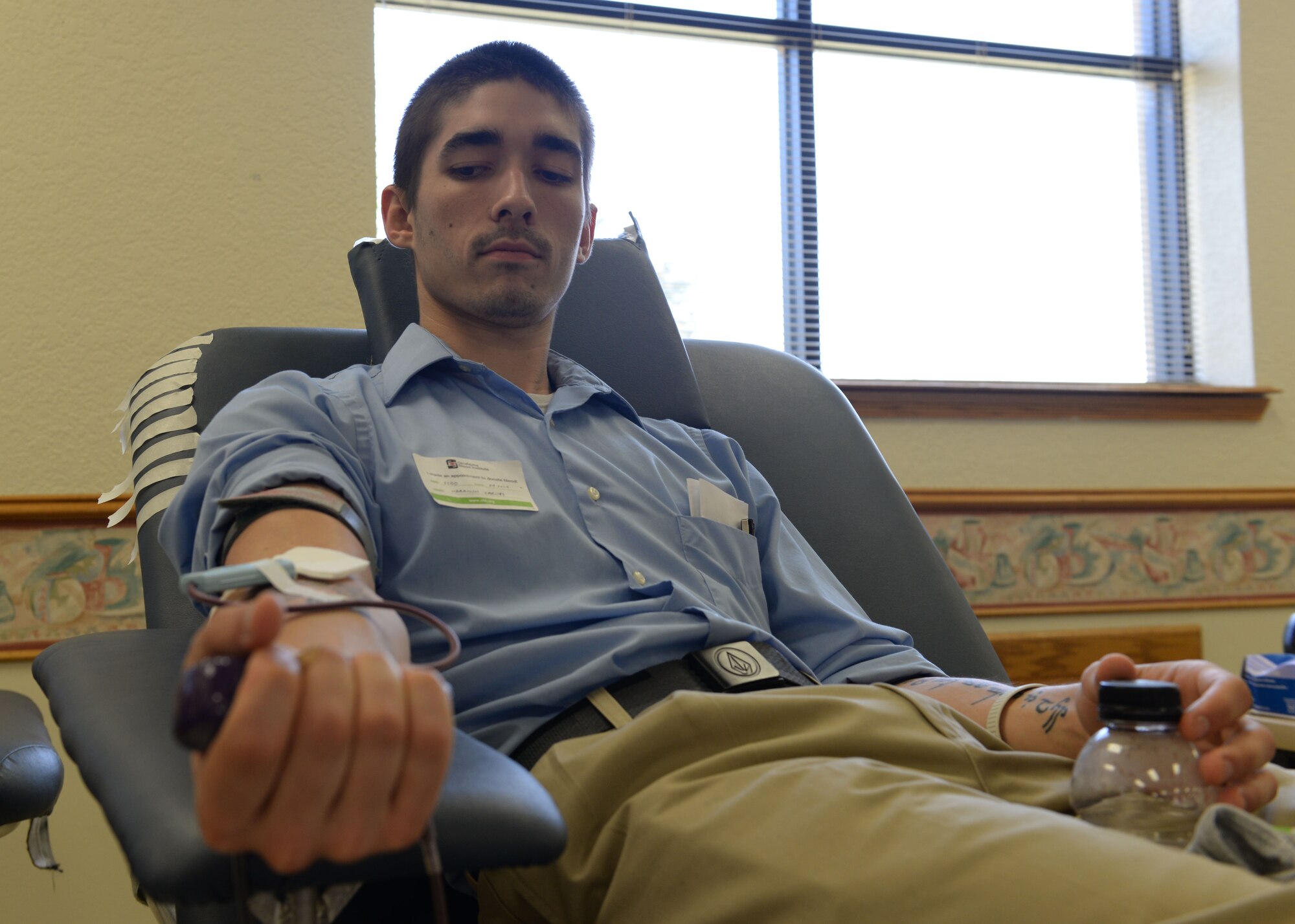 ALTUS AIR FORCE BASE, Okla. – Harrison Carnes, 97th Force Support Squadron arts and information specialist, gets his blood drawn at the chapel activities room during a blood drive, July 24, 2015. The Oklahoma Blood Institute hosted the blood drive and the blood will be used in area hospitals. (U.S. Air Force photo by Airman 1st Class Kirby Turbak/Released)