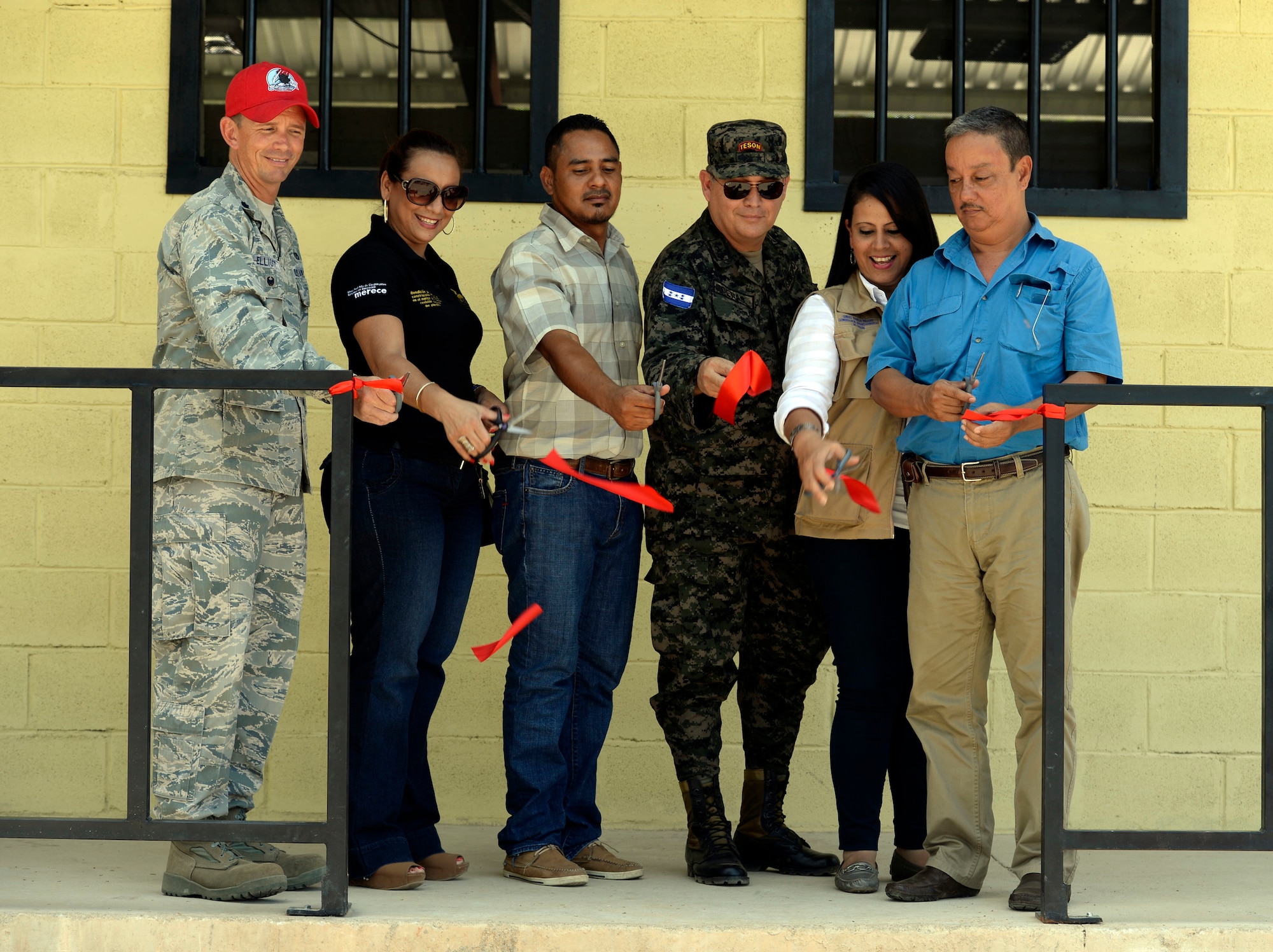 (From left to right) U.S. Air Force Lt. Col. Ryan Elliott, 823rd RED HORSE Squadron deputy commander and New Horizons Honduras exercise commander, out of Hurlburt Field, Fla., and a native of Grove City, Pa.; Director Doris Maradiaga, Colón Department of Education district director; Principal Abraham Ruiz, Gabriela Mistral school; Honduran Army Col. Rafael Deras, 15th Battalion commander: Ghisell Padilla, Colón Department governor; and Trujillo Mayor José Antonio Lainez cut the ribbon of the new two-classroom schoolhouse at the Gabriela Mistral school in Ocotes Alto, July 28, 2015, as part of the ribbon-cutting ceremony. The event marked the official opening of the building which was one of the key projects as part of the New Horizons Honduras 2015 training exercise taking place in around Trujillo, Honduras. New Horizons was launched in the 1980s and is an annual joint humanitarian assistance exercise that U.S. Southern Command conducts with a partner nation in Central America, South America or the Caribbean. The exercise improves joint training readiness of U.S. and partner nation civil engineers, medical professionals and support personnel through humanitarian assistance activities. (U.S. Air Force photo by Capt. David J. Murphy/Released)