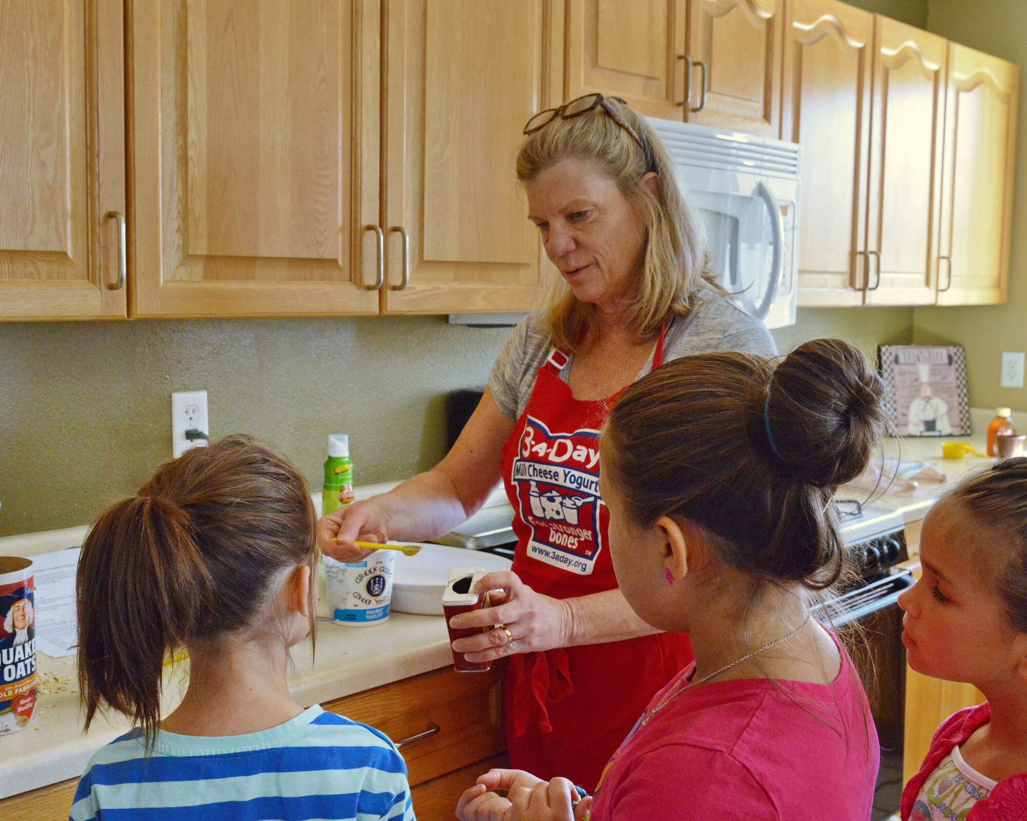 Judy Armgardt, “Cooking with Kids” class instructor, teaches kids how to measure ingredients. The class was hosted by Kirtland Family Housing. (Photo by Jamie Burnett)