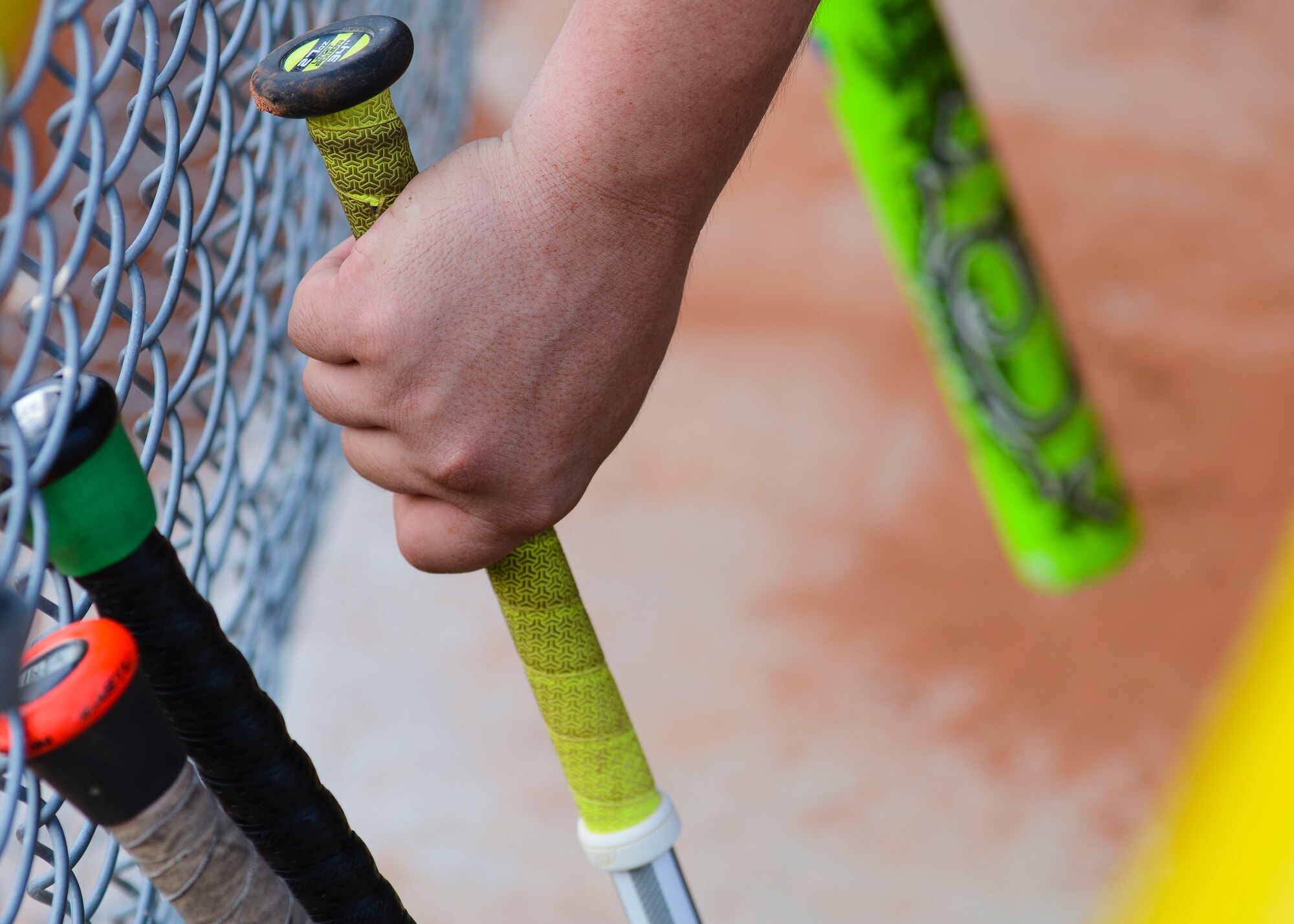 A softball player grabs a bat during an intramural game, July 27, 2015, at Aviano Air Base, Italy. Other intramural sports offered at Aviano include basketball, volleyball and flag football.  (U.S. Air Force photo by Senior Airman Austin Harvill/Released)