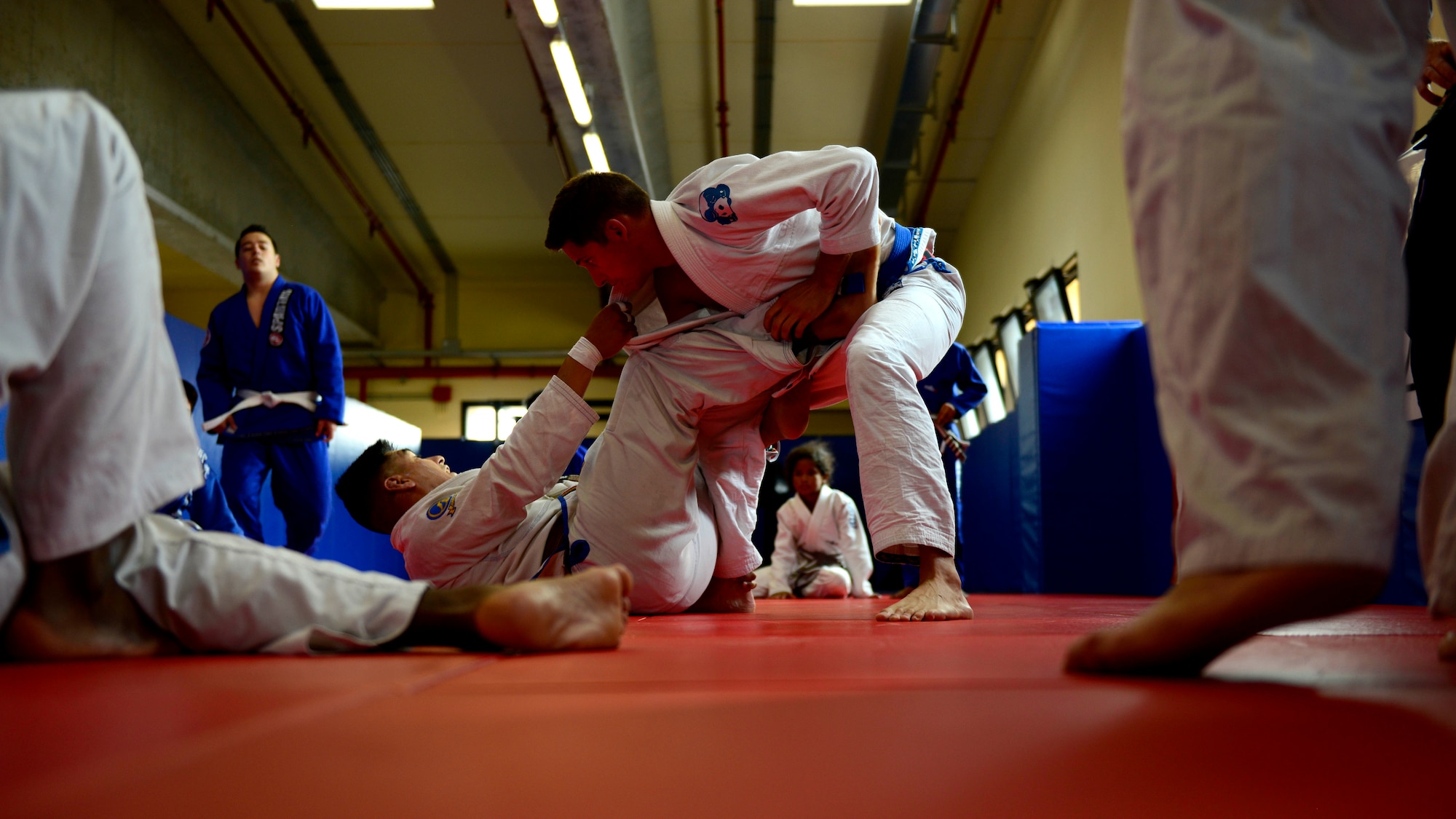 (From bottom) U.S. Air Force Master Sgt. Ruben Rivas, head instructor, and Staff Sgt. Jacob Collins, assistant instructor, a demonstrate jiu jitsu move, July 27, 2015, at Aviano Air Base, Italy. Jiu jitsu is a form of martial arts, which focuses on grappling and ground fighting. (U.S. Air Force photo by Senior Airman Areca T. Wilson/Released)