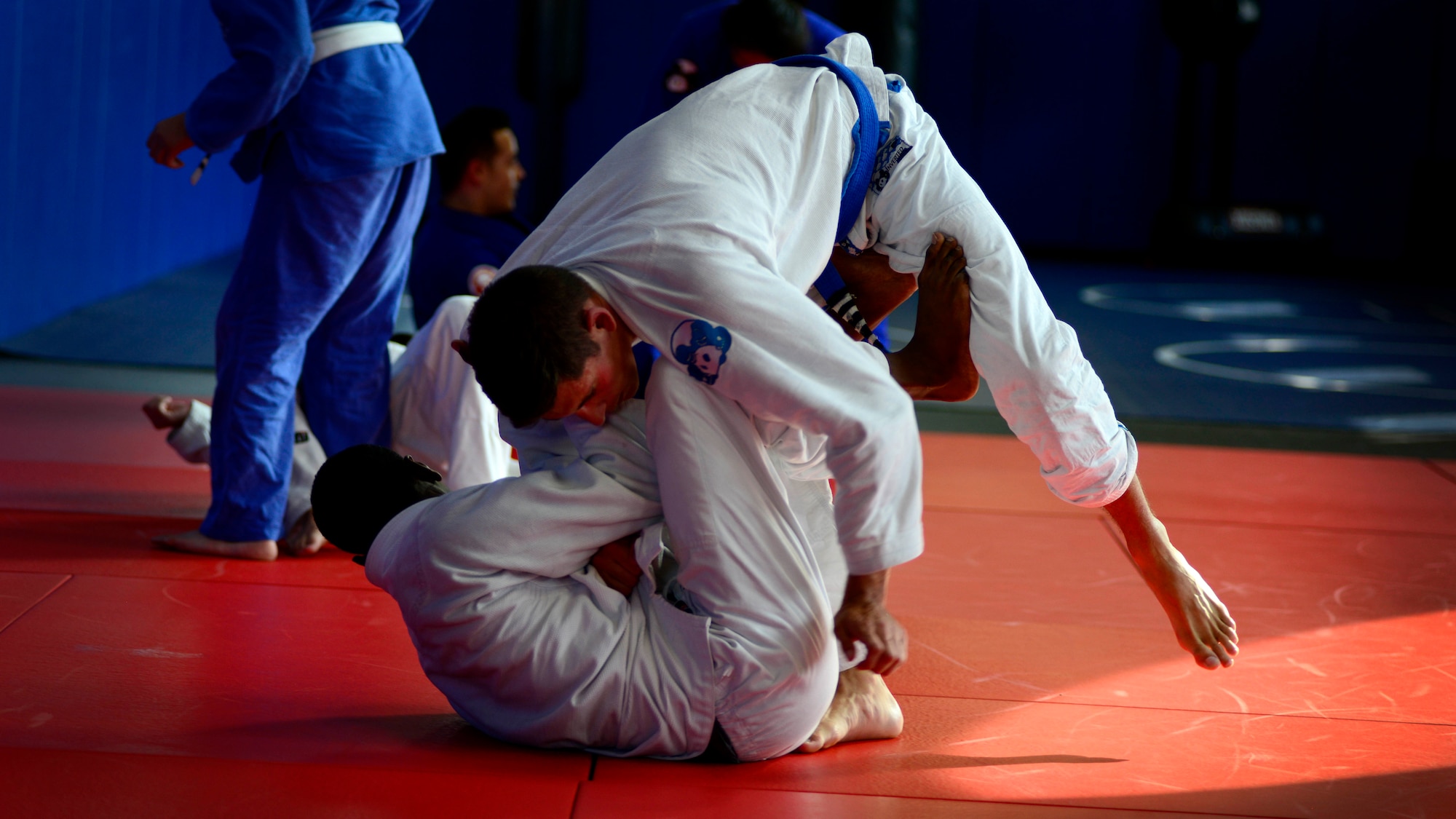 (From bottom) U.S. Air Force Airman 1st Class James Smith, 31st Civil Engineer Squadron electrical power production technician, and Staff Sgt. Jacob Collins, assistant instructor, practice jiu jitsu moves, July 27, 2015, at Aviano Air Base, Italy. Jiu jitsu is a form of martial arts, which focuses on grappling and ground fighting. (U.S. Air Force photo by Senior Airman Areca T. Wilson/Released)