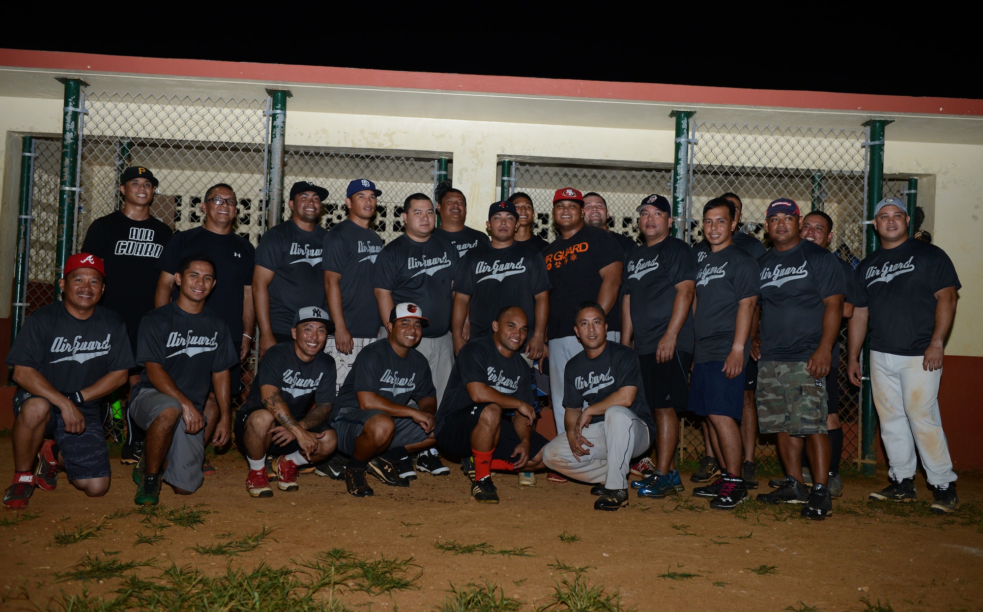 The 254th Air National Guard stands for a team photo at the end of the intramural softball game between the 36th Civil Engineer Squadron and Guam ANG July 28, 2015, at Andersen Air Force Base, Guam. The GU ANG won the game with a score of 16-12. (U.S. Air Force photo by Airman 1st Class Arielle Vasquez/Released)