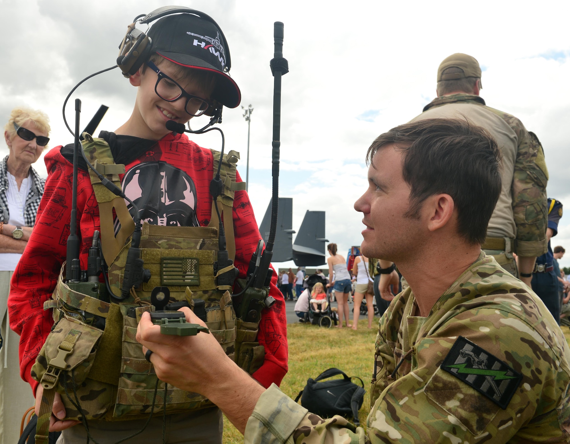 An Air Commando from the 321st Special Tactics Squadron shows a British child the radio communications equipment he uses in the field July 23, 2015, during the RAF Marham Family Day, in Norfolk, England. The event commemorated the 75th Anniversary of the Battle of Britain. (U.S. Air Force photo by Karen Abeyasekere) 