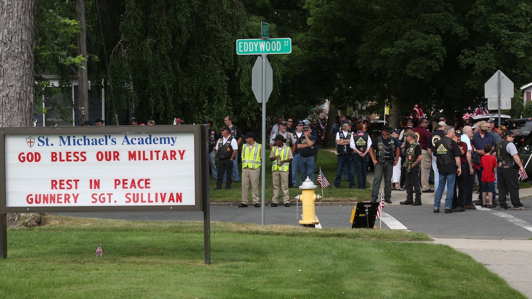 Family and friends of Gunnery Sgt. Thomas J. Sullivan line the streets outside Holy Cross Church in Springfield, Massachusetts, July 27, 2015 during funeral services for Sullivan, who was one of five victims of the Chattanooga, Tennessee shootings July 16, 2015. Along with friends and family, hundreds lined the route of the funeral procession to pay their respects. 