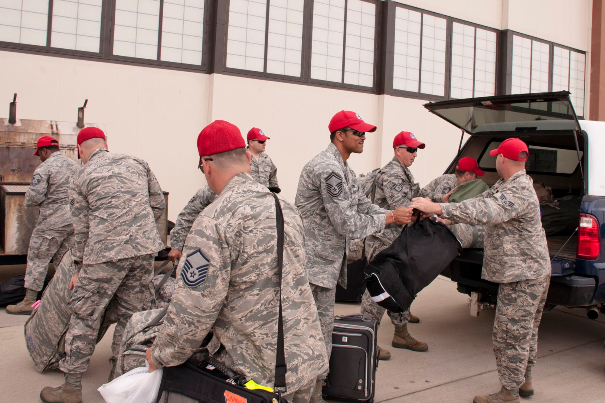 Members of the 307th RED HORSE Squadron unload their baggage to be processed before boarding a C-17 Globemaster III transport aircraft at Barksdale Air Force Base, La., May 17, 2015. The Airmen traveled to San Marcus, Calif., as part of the civilian-military innovative readiness training program, which provides the Services/components "hands-on" readiness training opportunities, while at the same time, providing a direct and lasting benefit to our communities. (U.S. Air Force photo by Master Sgt. Jeff Walston)