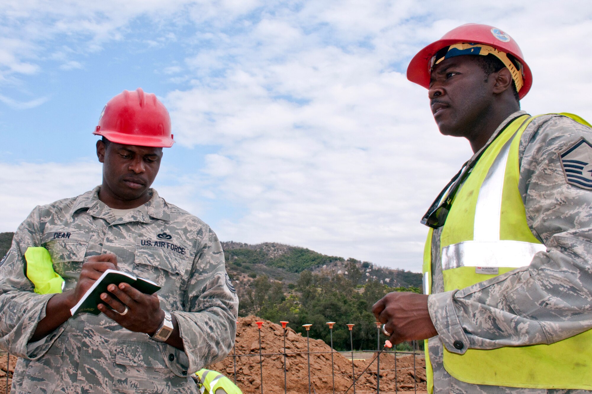 U.S. Air Force Master Sgts. James Dean and Dexter Hodge, discuss accomplishments of the day and plans for tomorrow at a construction site in San Marcos, Calif., June 9, 2015. Both Airmen are pavement and construction equipment operators assigned to the 307th RED HORSE at Barksdale Air Force Base, La., who are working on a project for Training, Education, Research and Innovation (TERI) Inc., a non-profit organization, dedicated to the education and assistance for children/adults with Autism and other special needs. (U.S. Air Force photo by Master Sgt. Jeff Walston)