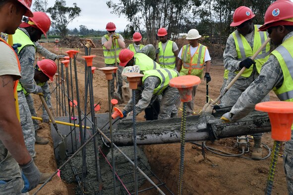 U.S. Air Force RED HORSE Airmen from numerous units pour a concrete footing for a perimeter wall in San Marcos, Calif., June 11, 2015. The project is part of the Innovative Readiness Training Program that gives personnel real-world, hands-on-training. (U.S. Air Force photo by Staff Sgt. Bryan Anderson-Wooten)