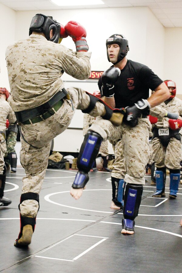 Second Lt. Matthew C. Newhouse, Marine Corps Reservist from Los Angeles, Calif., spars with Sgt. Adam C. Gregg, instructor trainer, during the Marine Corps Martial Arts Program instructors course in Raider Hall at The Basic School July 25. Marines practice the side kick, roundhouse kick, front kick and push kick in each sparring match.