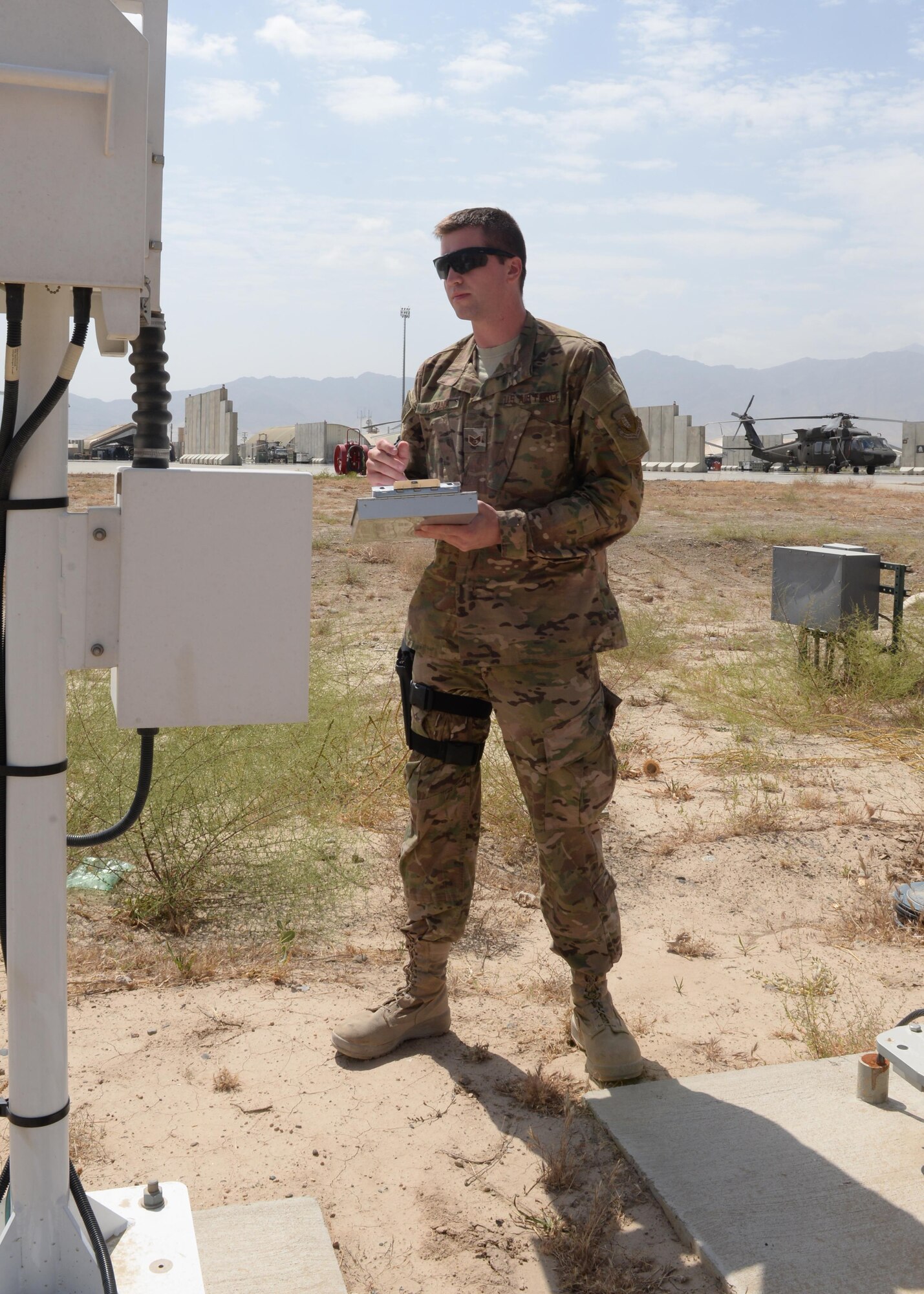 U.S. Air Force Staff Sgt. Travis Luzania, 455th Expeditionary Operations Support Squadron quality assurance evaluator, inspects a machine July 22, 2015, at Bagram Airfield, Afghanistan. Luzania is responsible for checking the work performed by contractors to ensure all equipment and programs are managed properly at all times. (U.S. Air Force photo by Senior Airman Cierra Presentado/Released)