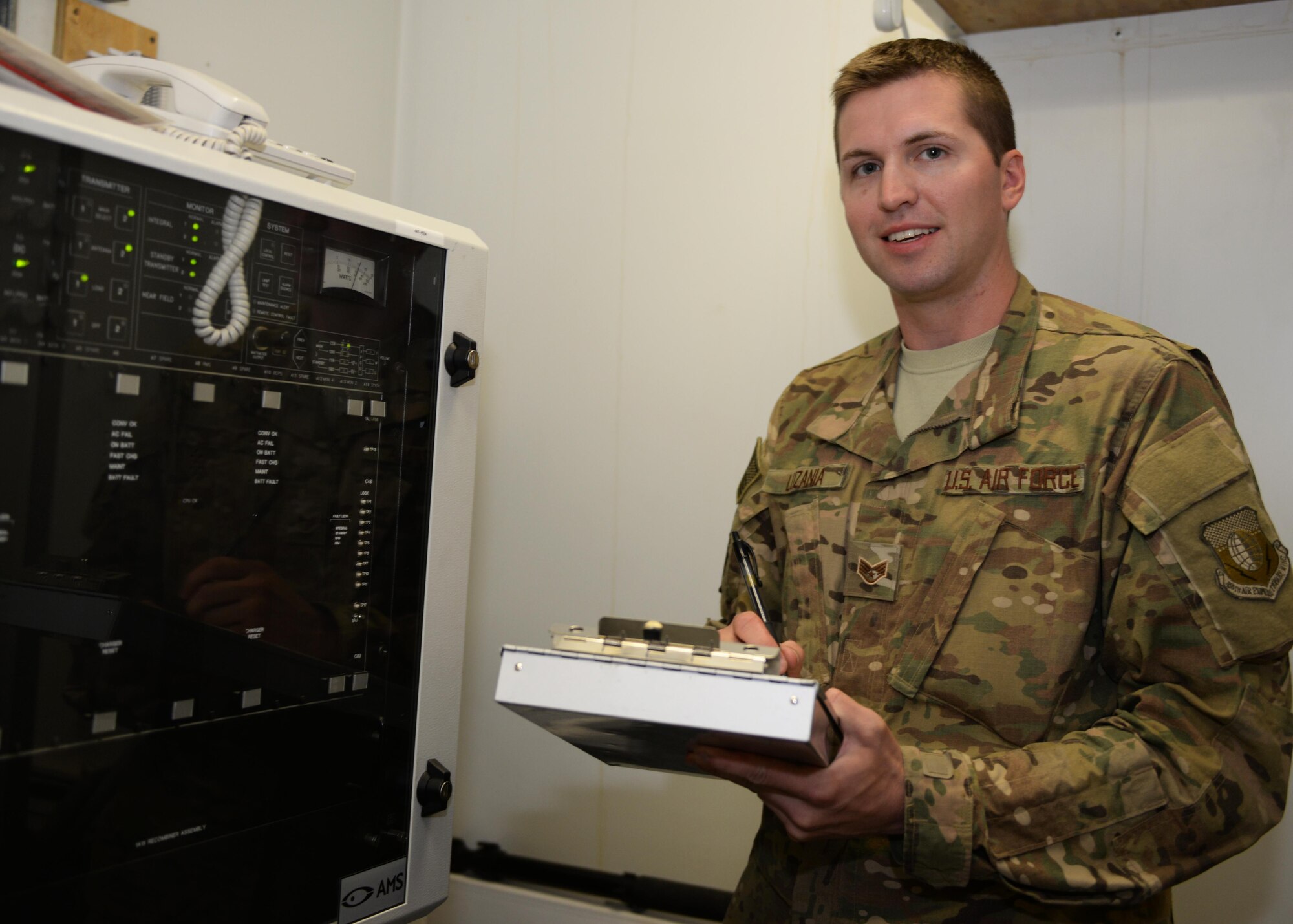U.S. Air Force Staff Sgt. Travis Luzania, 455th Expeditionary Operations Support Squadron quality assurance evaluator, poses for a photo after checking equipment July 22, 2015, at Bagram Airfield, Afghanistan. Luzania is responsible for checking the work performed by contractors to ensure all equipment and programs are managed properly at all times. (U.S. Air Force photo by Senior Airman Cierra Presentado/Released)