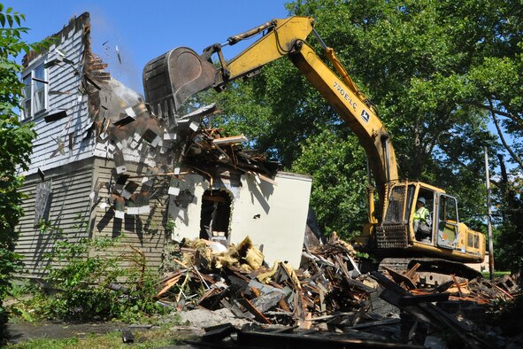 An excavator, operated by Tech. Sgt. Casey Klein, 910th Civil Engineer Squadron heavy equipment noncommissioned officer in charge, tears into a vacant, dilapidated house in the Taft School neighborhood on the city’s south side, July 23, 2015. Members of the 910th Civil Engineer Squadron, based at Youngstown Air Reserve Station, teamed up with a City of Youngstown Street Department team to kick off a joint blight removal project to demolish at least a dozen blighted structures in this neighborhood under the Air Force Community Partnership Program. The program is designed to identify and develop mutually beneficial partnerships between Air Force installations and surrounding communities. (U.S. Air Force photo/Master Sgt. Bob Barko Jr.)