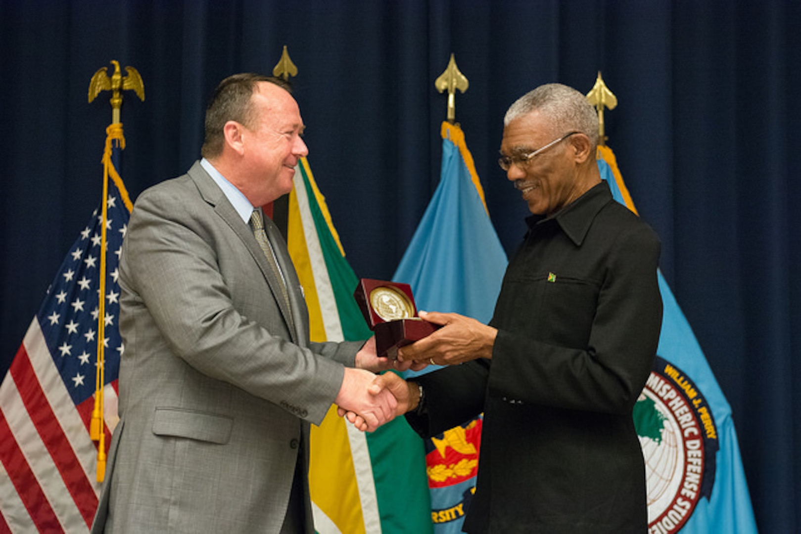President Granger and Perry Center Director Mark Wilkins exchange gifts following the graduation ceremony
