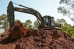 Spc. James Penn, a heavy equipment operator with the 921st Engineer Company, 528th Engineer Battalion, 225th Engineer Brigade, operates a hydraulic excavator to clear dirt from a pond being built as part of a new "Icon Corner" to mark the entrance to Louisiana State University at Alexandria, July 28, 2015. The dirt will be transported and used as fill for three new rugby pitches also being constructed at the school. 