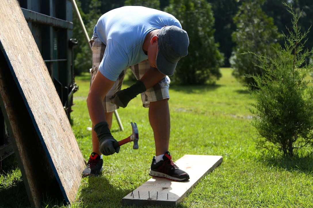 Marines lend a helping hand moving dry-wall during a veterans home build volunteer activity at Pamlico County, North Carolina, July 27, 2015. Marines with Marine Wing Communications Squadron 28 volunteered to assist in the construction of a home being built for Marine Corps veteran Warren Cottrell and his family. The volunteer event gave the Marines the opportunity to help better their community, while establishing relationships with other members of their squadrons outside of their work environment.