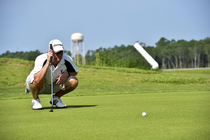Master Sgt. Chris Raines, Air Force Special Operations Command spectrum manager, lines up his shot during a golf tournament on Hurlburt Field, Fla., July 24, 2015. The golf tournament raised money for the Hurlburt Air Force Ball. (U.S. Air Force photo/Senior Airman Jeff Parkinson)