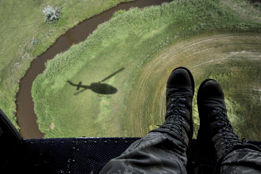 A UH-N1 Iroquois circles trees during a search and rescue training mission near Garrison, N.D., July 20, 2015. The crew practiced search and rescue operations in preparation for the upcoming Air Force Global Strike Command’s Global Strike Challenge. (U.S. Air Force photo/Senior Airman Stephanie Morris)