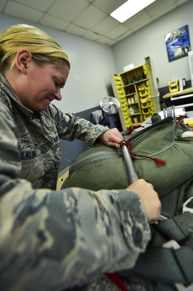 Staff Sgt. Ambyr Lalone, 1st Special Operations Support Squadron aircrew flight equipment craftsman, secures a parachute on Hurlburt Field, Fla., July 23, 2015. Aircrew flight equipment Airmen support Hurlburt’s flying squadrons by packing BA-22 parachutes designed for emergency bail-out. (U.S. Air Force photo/Senior Airman Jeff Parkinson)