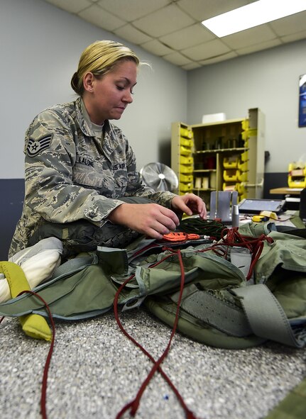 Staff Sgt. Ambyr Lalone, 1st Special Operations Support Squadron aircrew flight equipment craftsman, rigs a parachute harness on Hurlburt Field, Fla., July 23, 2015. Aircrew flight equipment Airmen support Hurlburt’s flying squadrons by packing BA-22 parachutes designed for emergency bail-out. (U.S. Air Force photo/Senior Airman Jeff Parkinson)