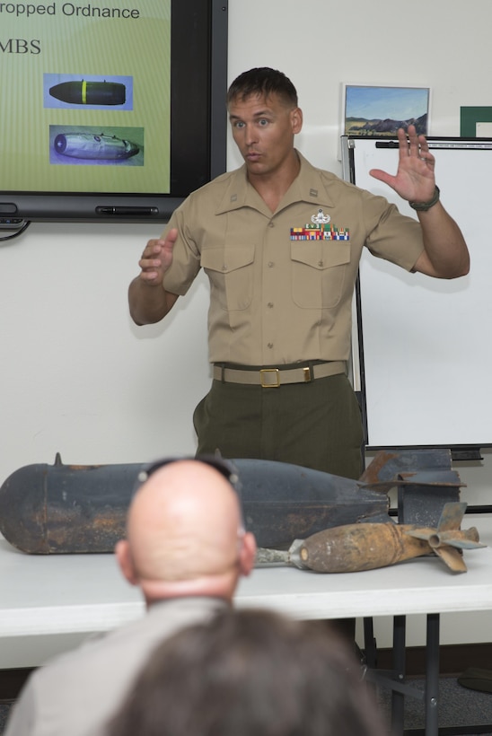Capt. Erin Roush, explosive ordnance disposal officer, explains the make-up of WWII dynamite to Joshua Tree staff at Joshua Tree National Park Headquarters, July 23, 2015. (Official Marine Corps photo by Lance Cpl. Connor Hancock/Released)