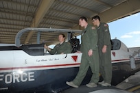 Major Erin Shay, (left) 559th Flying Training Squadron flight instructor, briefs Air Force Academy cadets Maxwell Edson (center) and Robert Doby on the T-6 Texan ll aircraft July 28, 2015 at Joint Base San Antonio-Randolph.  The 559th FTS provides training for instructor pilots utilizing the T-6 Texan ll aircraft, which is used to teach pilots basic flying skills.  (U.S Air Force photo by Joel Martinez/Released)