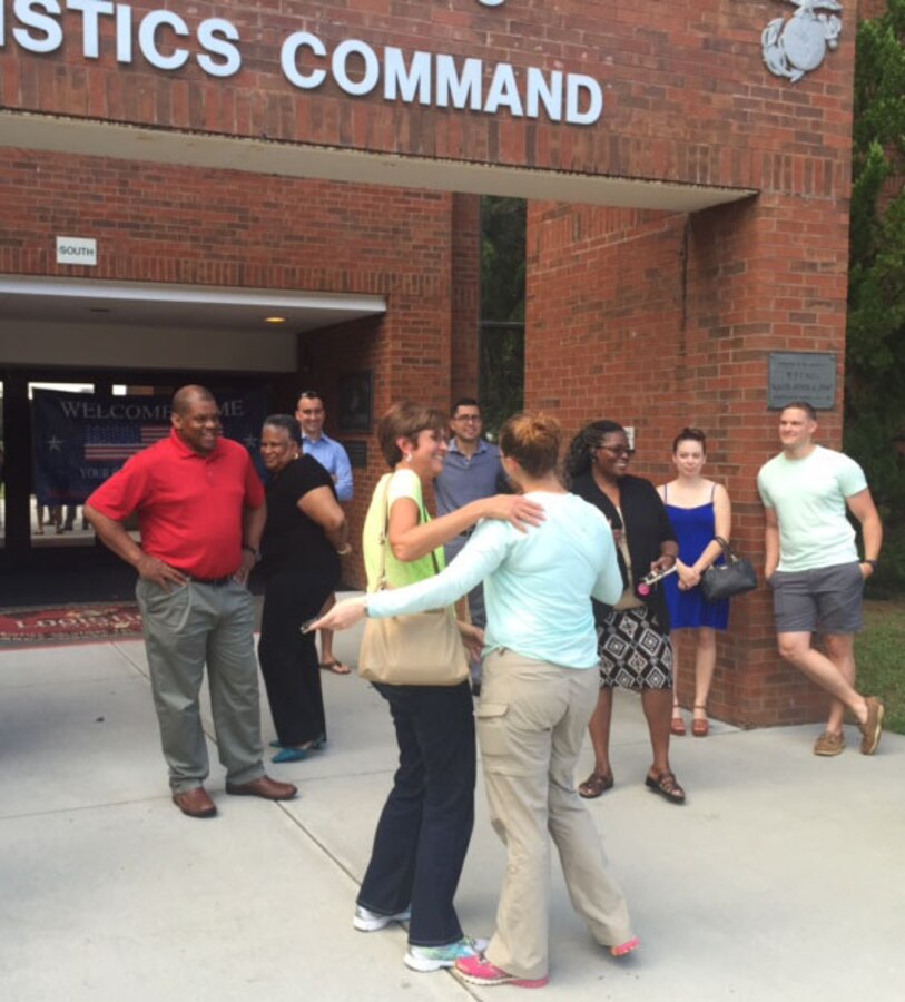 Marines and civilian-Marines welcome home Capt. Kelly Crone (center) contracting officer, Marine Corps Logistics Command, after a six-and-a-half-month deployment to Djibouti, Africa, July 24.