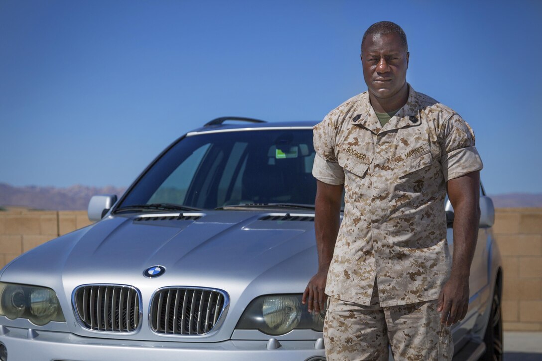 Master Sgt. Justin Booker, Combat Center, equal opportunity advisor, stands in front of his BMW X5 4.4. Booker finds an interest in detailing and fixing cars, and hopes to one day be the defensive coordinator for the Baltimore Ravens. (Official Marine Corps photo by Lance Cpl. Connor Hancock/Released)