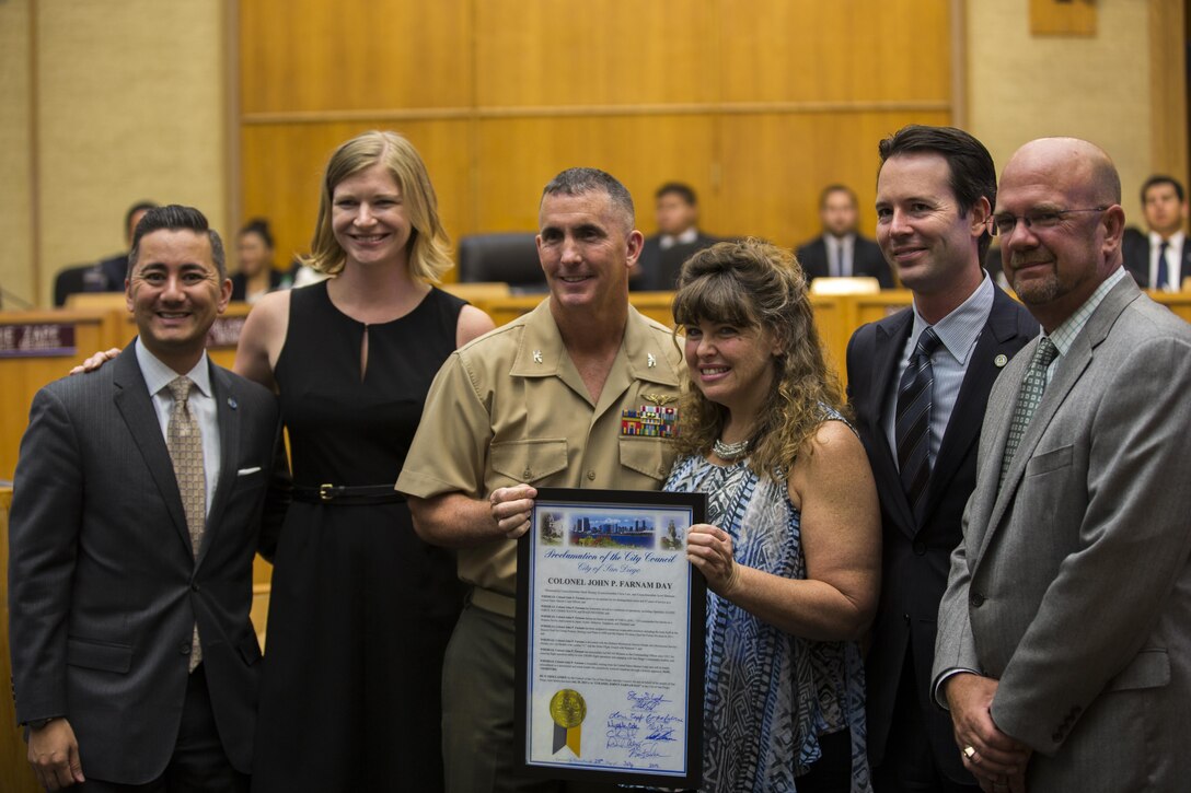 Col. John P. Farnam, center, commanding officer of Marine Corps Air Station Miramar, poses with the plaque after a proclamation for “Colonel John P. Farnam Day” at the San Diego City Council, July 28. Farnam received the plaque from San Diego council members to commemorate the proclaimed day in his honor. (U.S. Marine Corps photo by Cpl. Michael Thorn/Released)