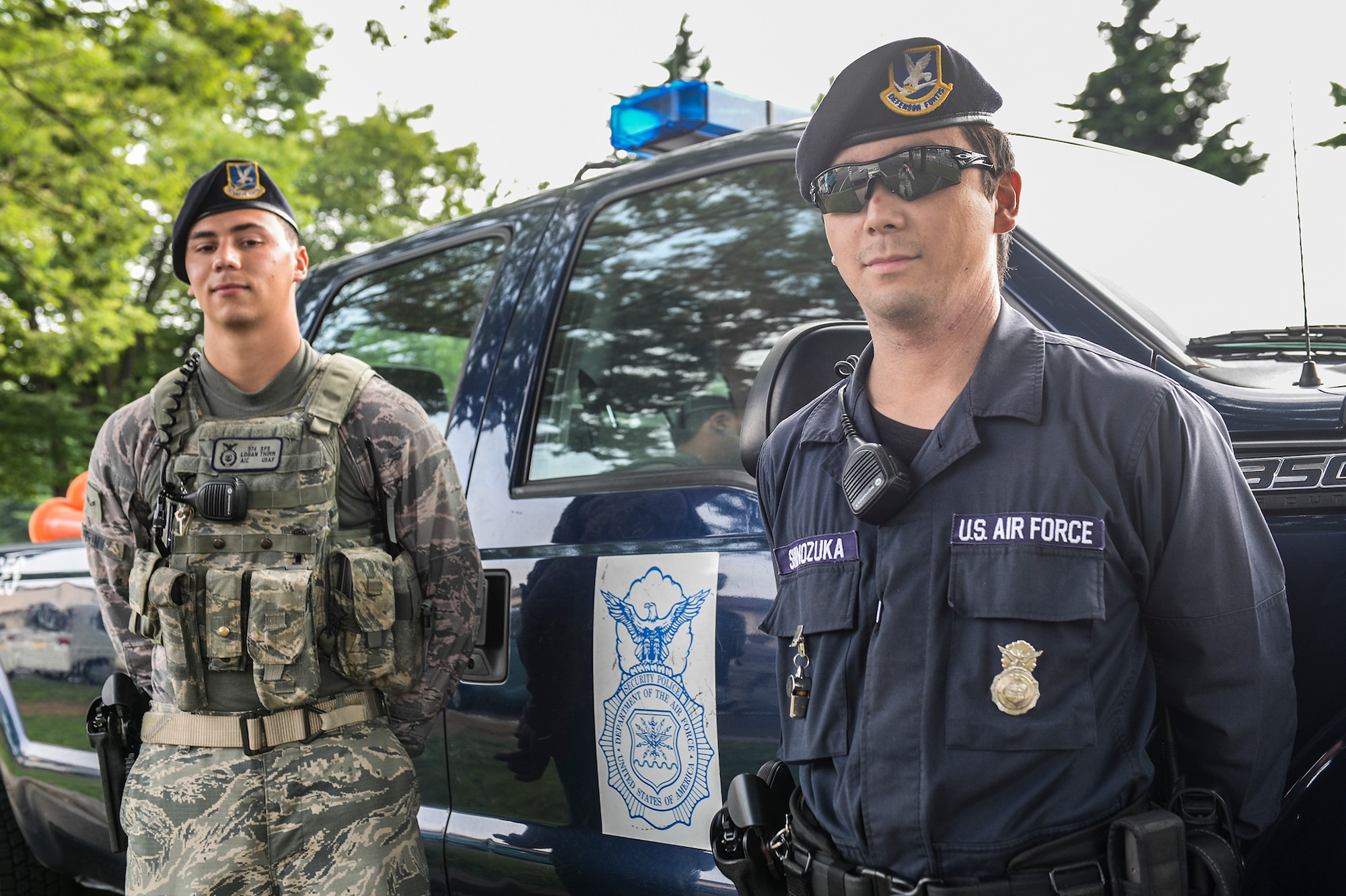 U.S. Air Force Airman 1st Class Logan Thimm, 374th Security Forces Squadron patrolman, and Masafumi Shinozuka, civilian guard, pose in front of a patrol truck at Yokota Air Base, Japan, July 29, 2015. Civilian guards have protected Yokota’s mission by securing the gates for years, but now they have begun augmenting for security forces personnel on patrol. (U.S. Air Force photo by Airman 1st Class Elizabeth Baker/Released)