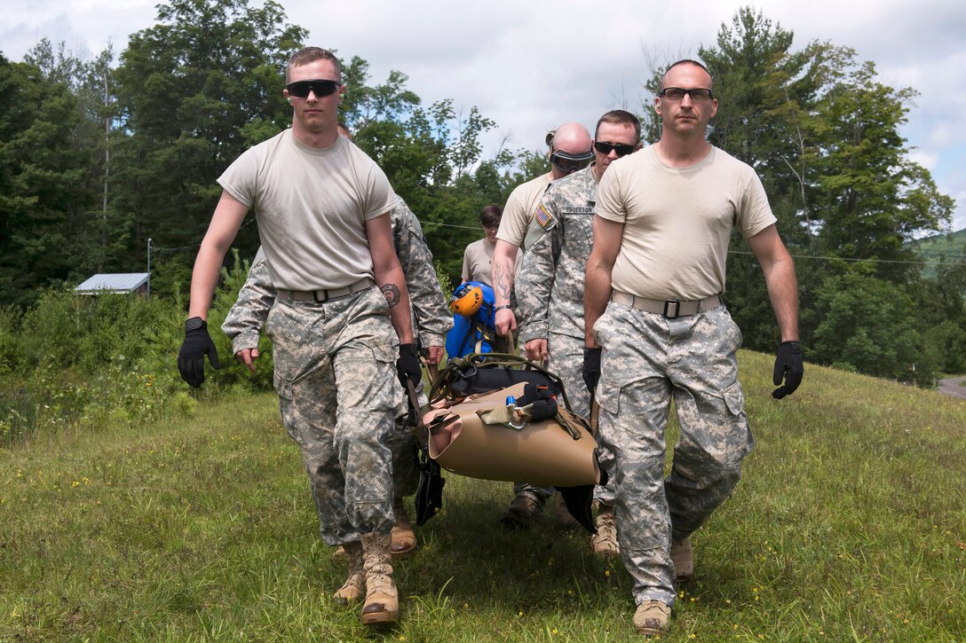 Army Spc. Zachary Isham, left, and Army Staff Sgt. Paul Jardine lead a team carrying a litter on Camp Ethan Allen Training Site in Jericho, Vt., July 22, 2015. Isham and Garrison are assigned to the Vermont National Guard. They are working with the Army Medical Department Board, Medevac Proponency Directorate and the Army Aeromedical Research Lab to evaluate five flexible litters.
