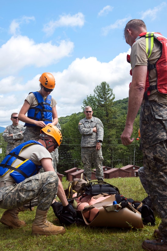 Army Spc. Zachary Isham, left kneeling, prepares a litter for a water hoist training on Camp Ethan Allen Training Site in Jericho, Vt., July 22, 2015. Isham is a medic assigned to the Vermont National Guard's State Medical Detachment, Garrison Support Command.