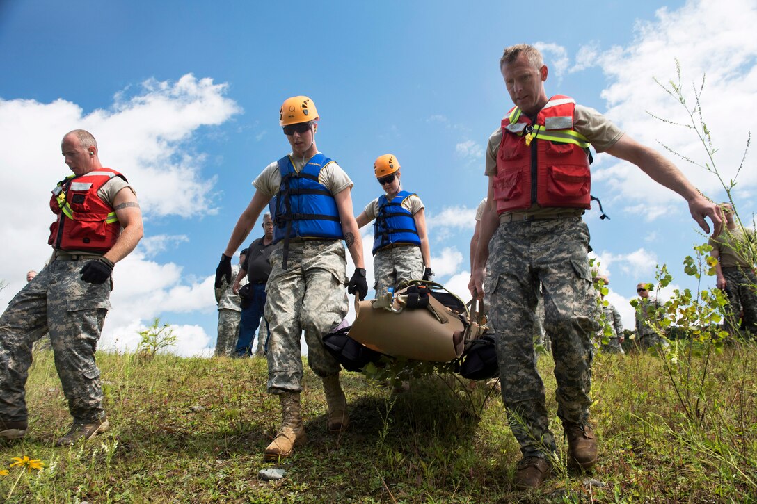 Soldiers carry a litter to participate in water-hoist training on Camp Ethan Allen Training Site in Jericho, Vt., July 22, 2015. The soldiers are assigned to the Vermont National Guard.