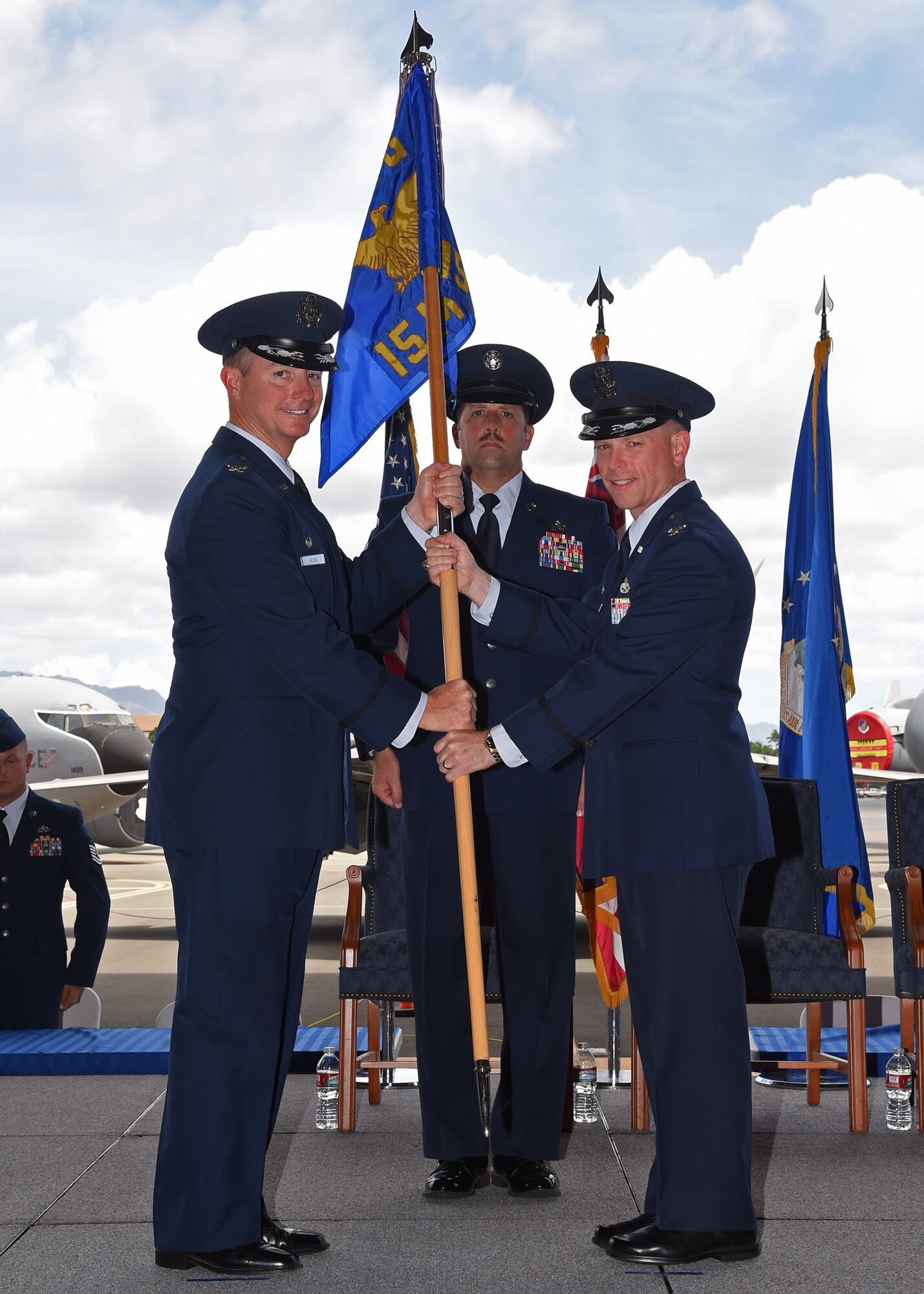 Col. Randy Huiss, 15th Wing commander, passes the guidon to Col. Robert Copes during the 15th Maintenance Group change of command ceremony on Joint Base Pearl Harbor-Hickam, Hawaii, July 28, 2015. As the 15 MXG commander, Copes will lead and provide operational direction to an integrated force of 500 active duty, Hawaii Air National Guard, civilian and contractor members supporting C-17, F-22 and C-37 and C-40 Special Assigned Airlift Mission aircraft to meet global airlift, global strike and theater security mission requirements. Additionally, his group supports 6,500 joint and allied aircraft transiting through Hickam each year. (U.S. Air Force Photo by Tech Sgt. Aaron Oelrich/Released)