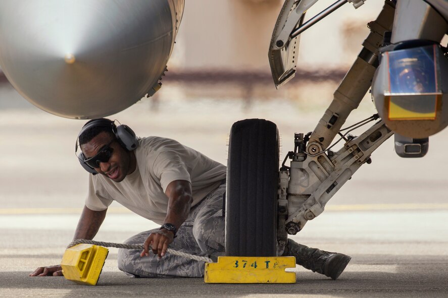 Staff Sgt. Eric Carrasquillo, 374th Maintenance Squadron transient alert craftsman, removes the wheel chocks from an F-16 Fighting Falcon at Yokota Air Base, Japan, July 24, 2015. Yokota's transient alert conducts the mission 24/7 and provides vital assistance to aircraft and crew members. (U.S. Air Force photo by Osakabe Yasuo/Released)