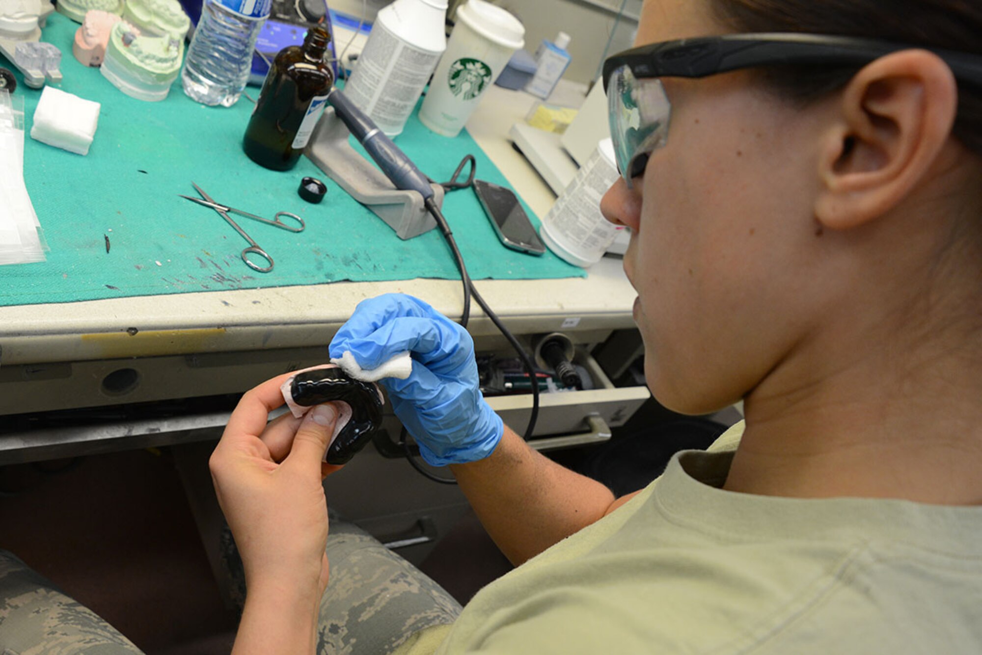 Staff Sgt. Katlyn Dumancas, 673d Dental Squadron laboratory technician, polishes a finished custom-fit sports mouth guard at the 673d Dental Clinic on Joint Base Elmendorf-Richardson July 22. The dental laboratory creates the mouth guards from an impression by generating a mold then forming the plastic guard around it. (U.S. Air Force photo/Airman Christopher R. Morales)