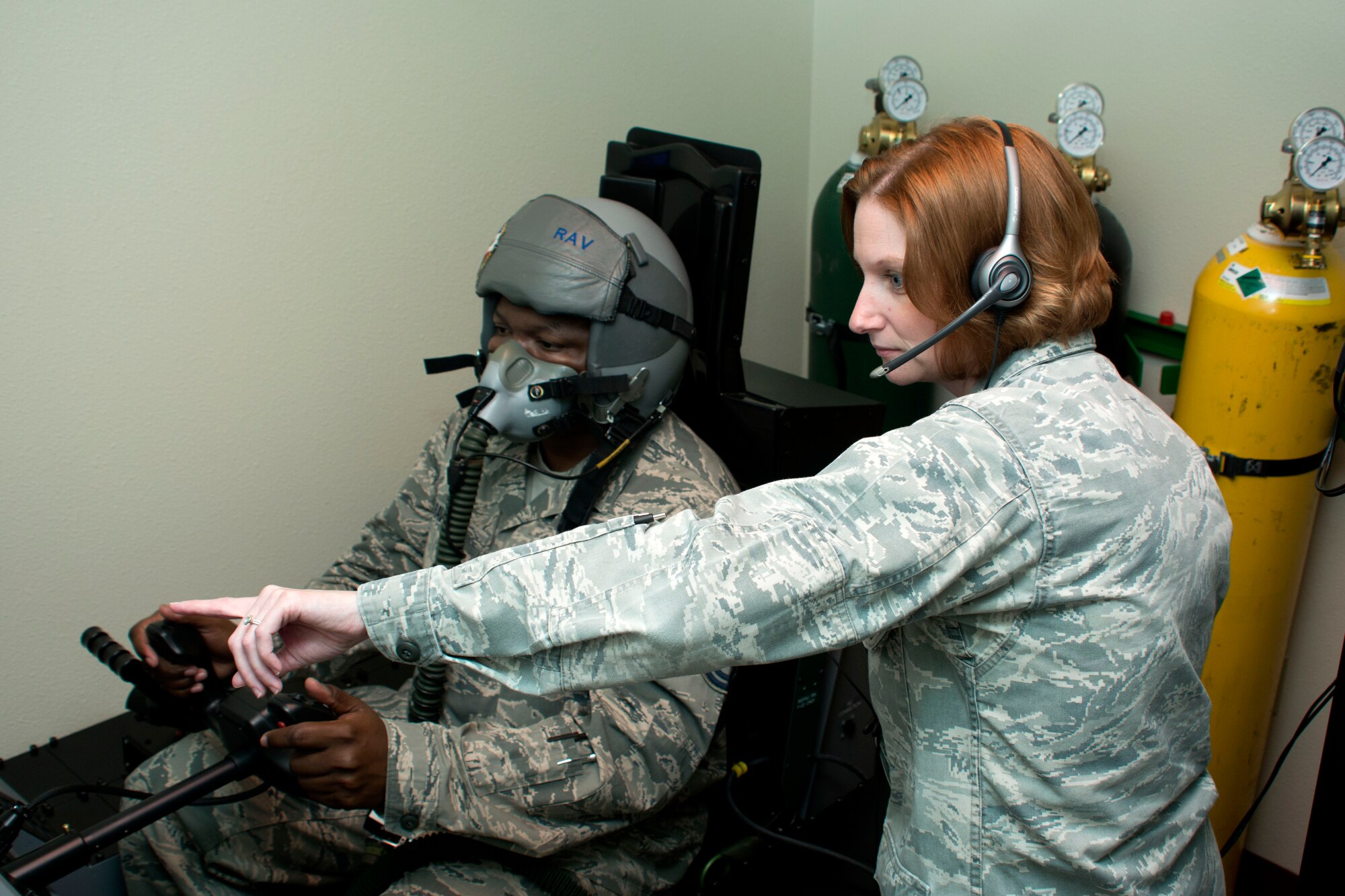 Capt. Irena Farlik,60th Medical Operations Squadron aerospace and operational physiologist,  and Master Sgt. Keith Ravenel, 60th Medical Operations Squadron aerospace physiology technician, demonstrate the process in which aircrew members utilize the Reduced Oxygen Breathing Device/Hypoxia Familiarization Trainer, July 8, 2015, as part of mandatory refresher physiology training at Travis Air Force Base, California. (U.S. Air Force photo by Senior Airman Charles Rivezzo)