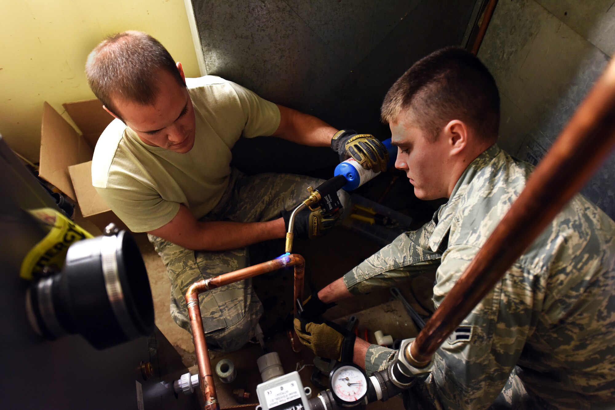 Senior Airman Julian Donahue and Airman 1st Class Joseph Konecny, 341st Civil Engineer Squadron Heating Ventilation and Air Conditioning technicians, solder two pieces of copper using a turbo torch July 30, 2015, at Malmstrom Air Force Base, Mont. HVAC completed 102 job orders for the month of July. (U.S. Air Force photo/Chris Willis)